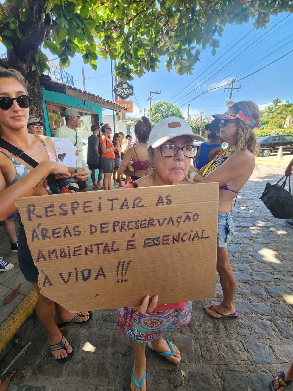 Mulher segura cartaz contra construção de empreendimento em Pipa — Foto: Gabriela Lyra/Cedida