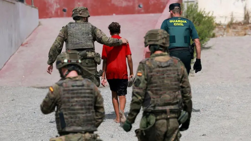 Soldados escoltam criança em Ceuta — Foto: Reuters
