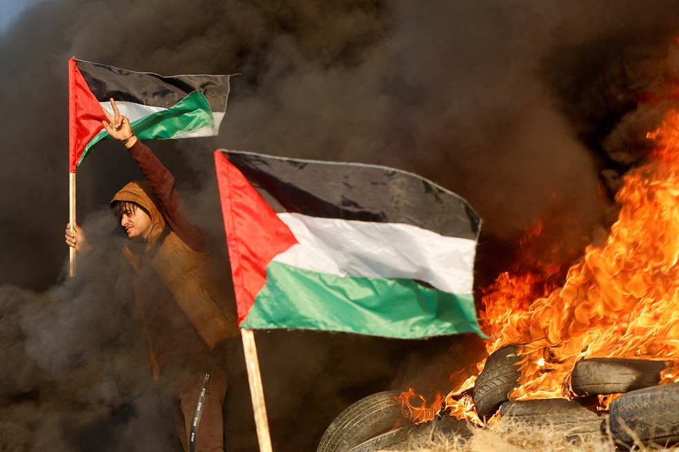 Homem segura bandeira da Palestina durante confronto com forças de Israel, em 27 de janeiro de 2023 — Foto: Mohammed Salem/Reuters