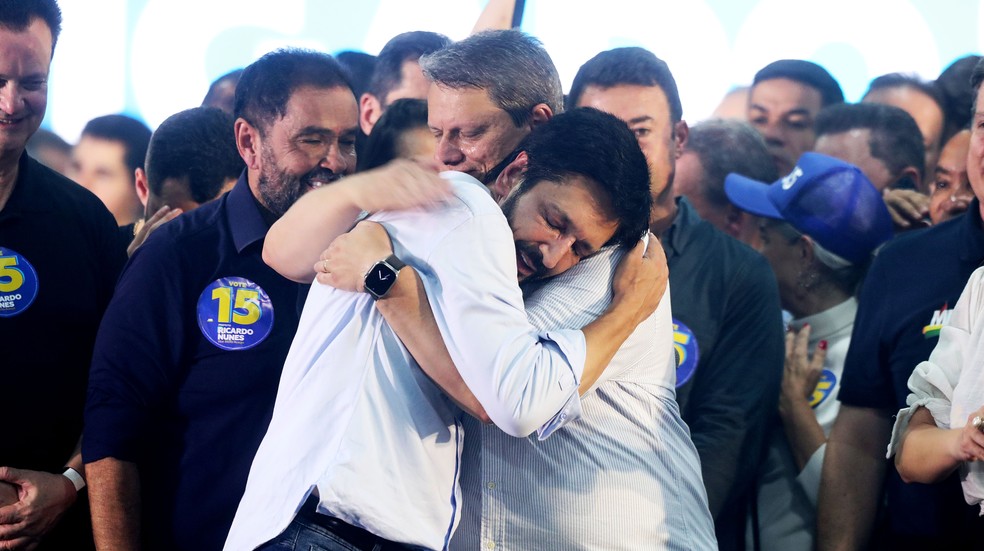 O prefeito reeleito Ricardo Nunes (MDB) e o governador Tarcísio de Freitas (Republicanos) se abraçam após anúncio de vitória na eleição de São Paulo, em 27/10/2024. — Foto: DANIEL TEIXEIRA/ESTADÃO CONTEÚDO