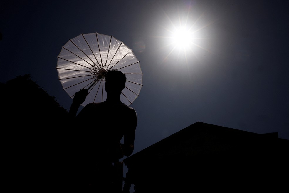 Homem vende guarda-chuvas durante onda de calor em toda a Itália, em Roma, em 19 de julho de 2023 — Foto: Guglielmo Mangiapane/Reuters