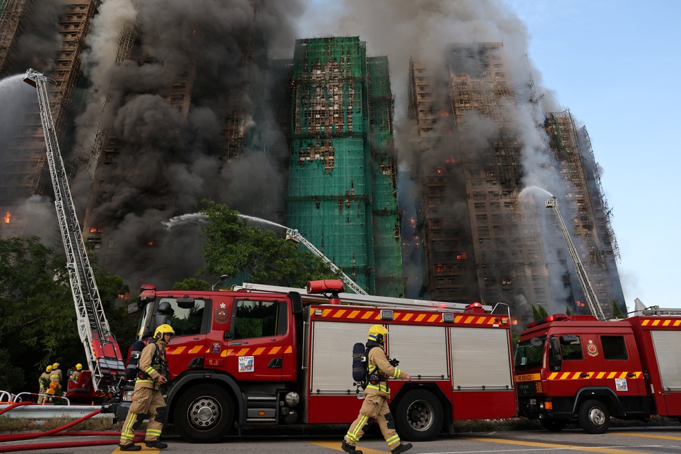 Bombeiros em frente a conjunto de arranha-céus atingido por incêndio em Hong Kong em 26 de novembro de 2025. — Foto: REUTERS/Tyrone Siu