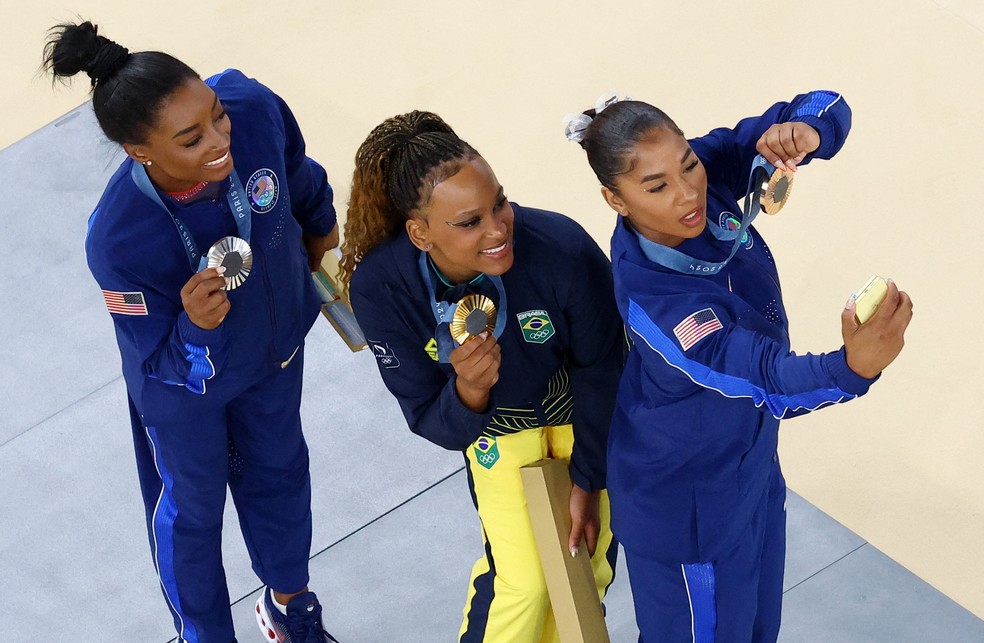 As medalhistas Jordan Chiles, Rebeca Andrade e Simone Biles tiram selfie no pódio de Paris com o Z Flip6 — Foto: Athit Perawongmetha/Reuters