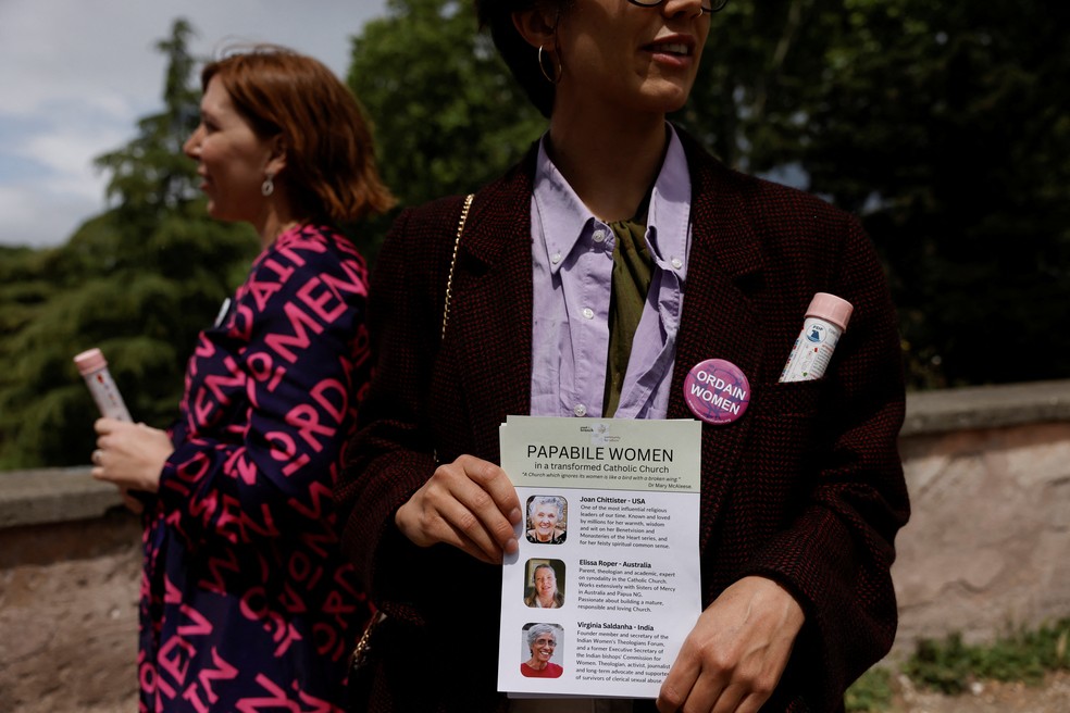 Manifestante segura uma lista de mulheres pap&aacute;veis, pedindo pela igualdade das mulheres na Igreja Cat&oacute;lica &mdash; Foto: REUTERS/Matteo Minnella