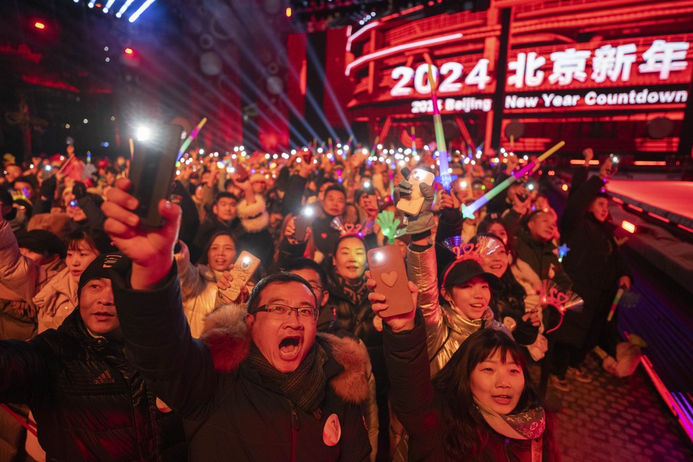 Foliões comemoram a contagem regressiva para o ano novo em Pequim, na China. — Foto: Ng Han Guan/ AP