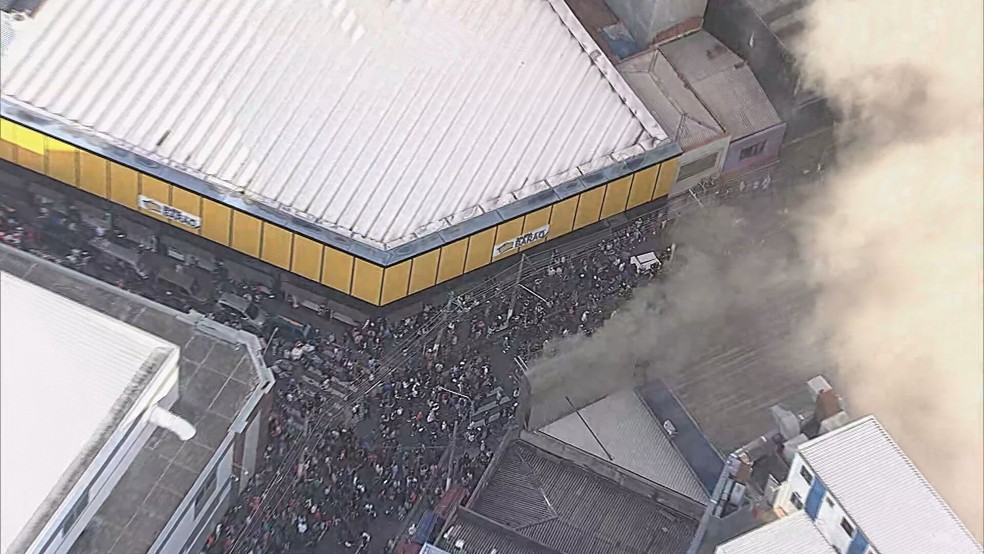 Movimentação de pedestres próximo de um shopping de compras na rua Barão de Ladário, no Brás, Centro de São Paulo, atingido por um incêndio. — Foto: Reprodução/TV Globo