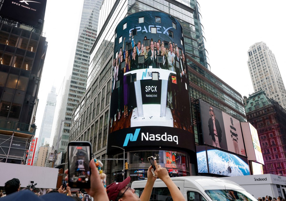 As pessoas se reúnem para assistir a uma transmissão ao vivo com o CEO da SpaceX, Elon Musk, no dia da oferta pública inicial (IPO) da SpaceX no Nasdaq MarketSite, em Nova York — Foto: REUTERS/Jeenah Moon