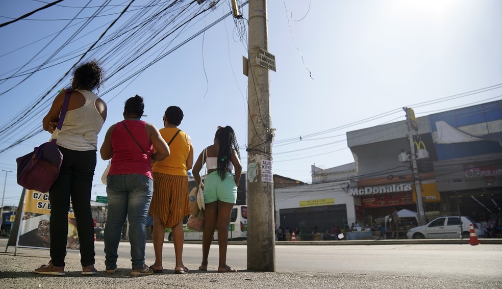 Vale qualquer sombra: em Madureira, pessoas esperam o ônibus na sombra do poste — Foto: Marcos Serra Lima/g1/Arquiv
