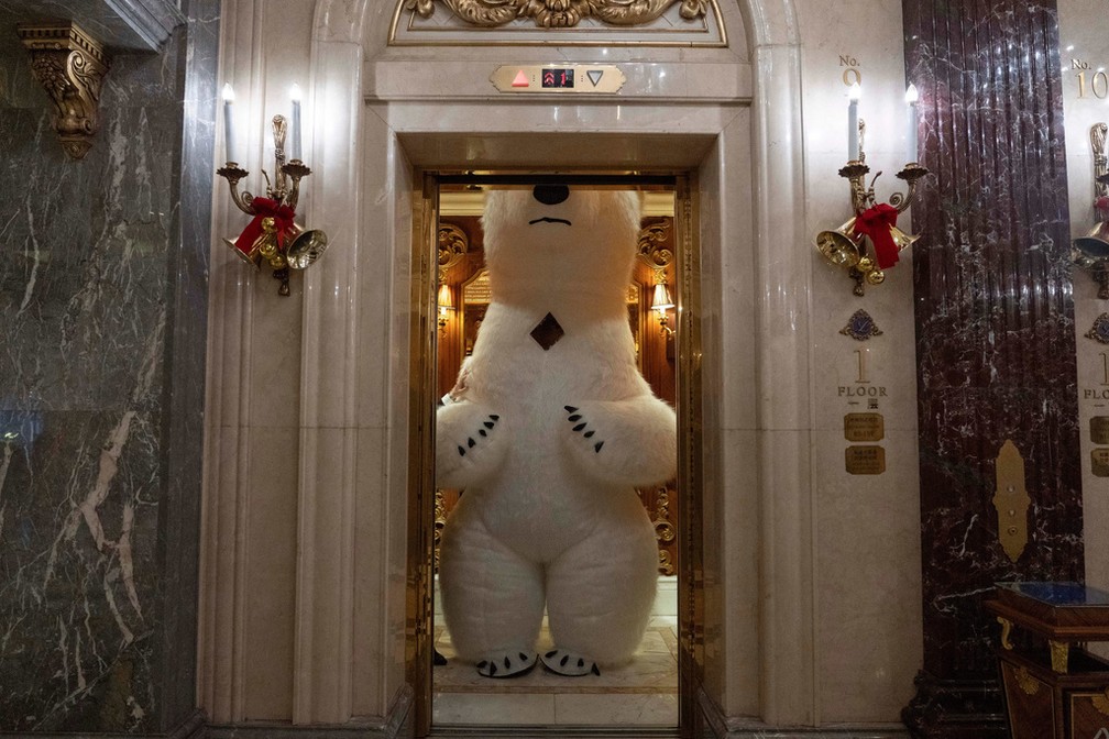 Pessoa vestida de urso polar dentro de um elevador na véspera do Natal em Pequim (China). — Foto: Ng Han Guan/AP