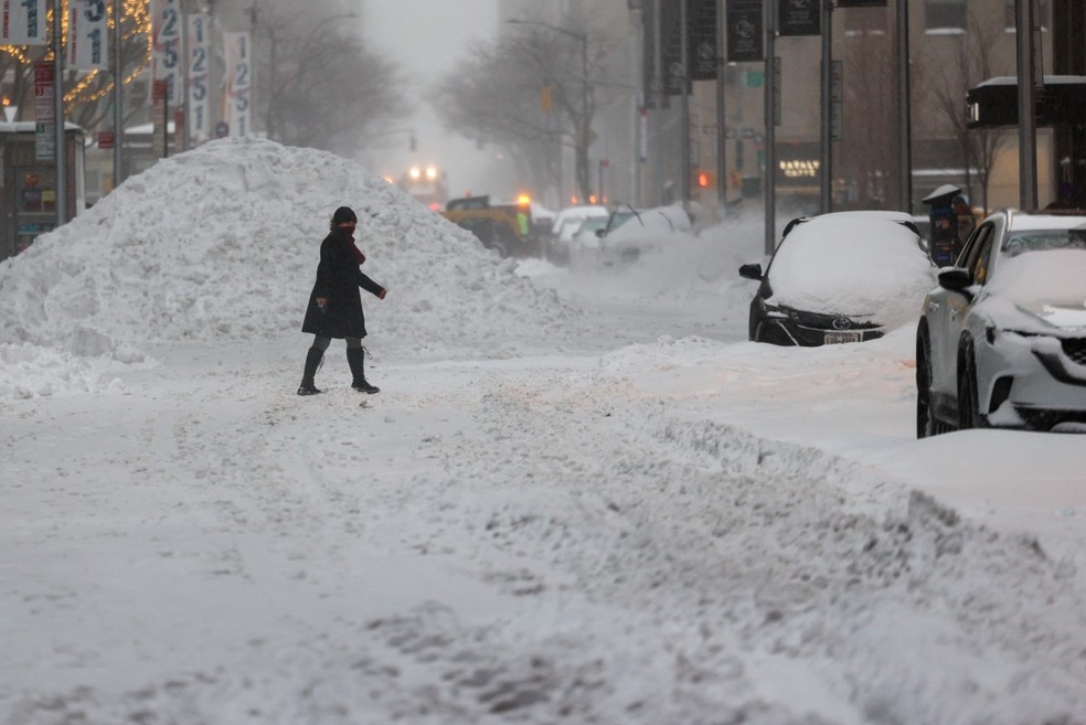 Uma mulher caminha por uma rua coberta de neve em Nova York. — Foto: CHARLY TRIBALLEAU / AFP