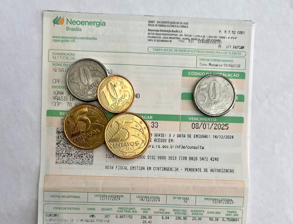 Conta de energia de Brasília com moedas em cima — Foto: Divulgação/Neoenergia