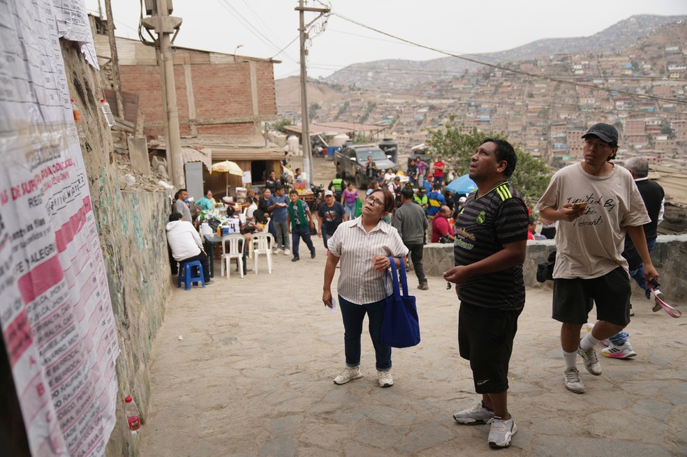 Eleitores consultam lista na porta de seção eleitoral em Lima, no Peru, durante o segundo turno das eleições presidenciais no país, em 7 de junho de 2026. — Foto: Rodrigo Abd/ Reuters