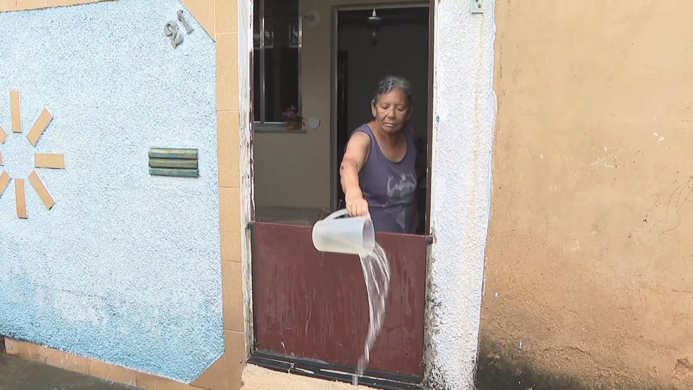 Moradora de Campo Grande tira água de dentro de casa com jarra — Foto: Reprodução/ TV Globo