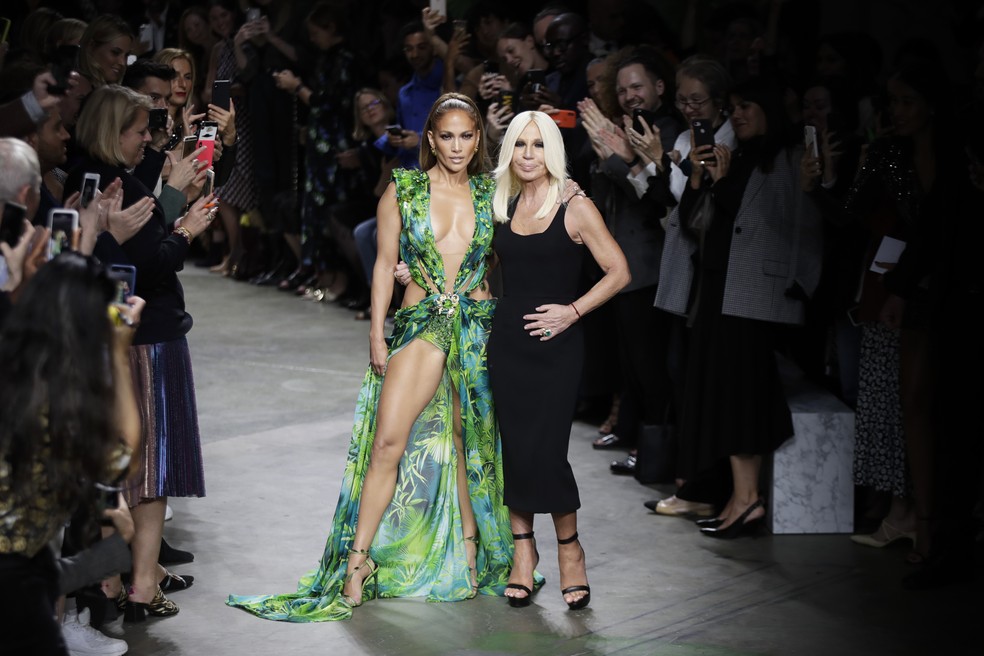 Estilista Donatella Versace recebe os aplausos pelo desfile na Semana de Moda de Milão nesta sexta (20), ao lado da atriz Jennifer Lopez — Foto: Luca Bruno/AP