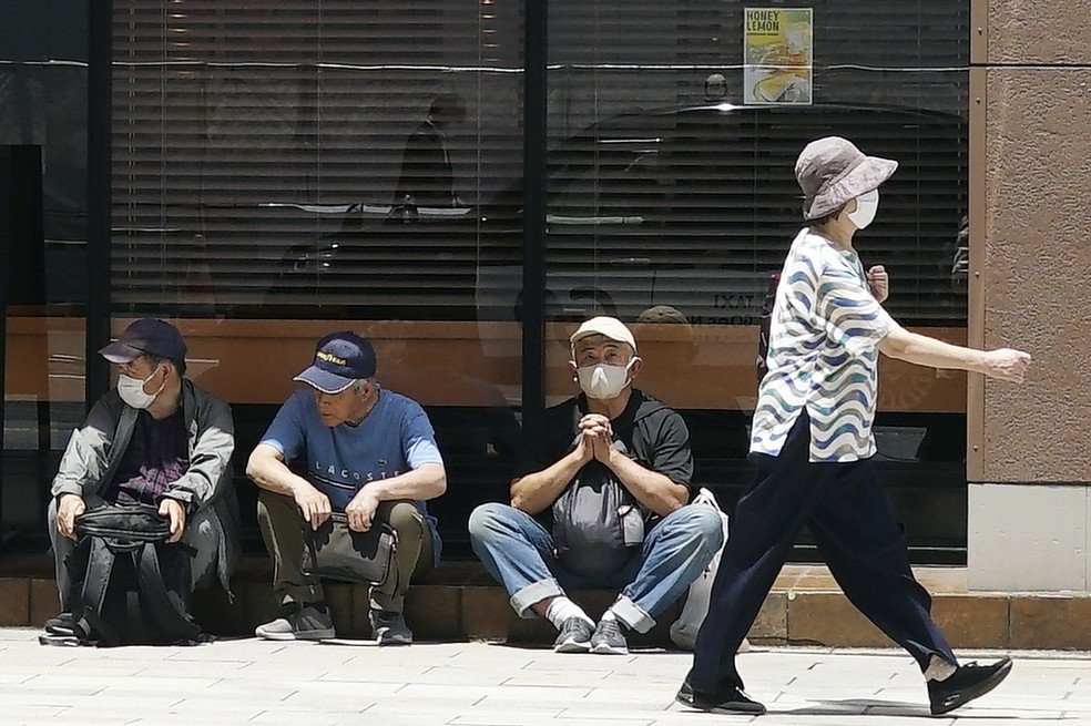 Pessoas descansam em sombra em Tóquio, no Japão, em meio a onda de calor incomum e prematura no país. — Foto: Eugene Hoshiko/ AP