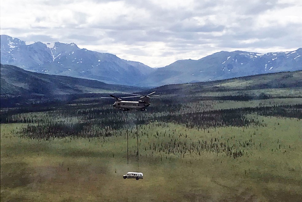 Helicóptero carrega ônibus que ficou famoso no livro e no filme 'Na natureza selvagem' sobre o Parque Nacional de Denali, no Alasca — Foto: Seth Lacount/Guarda Nacional do Alasca/AFP