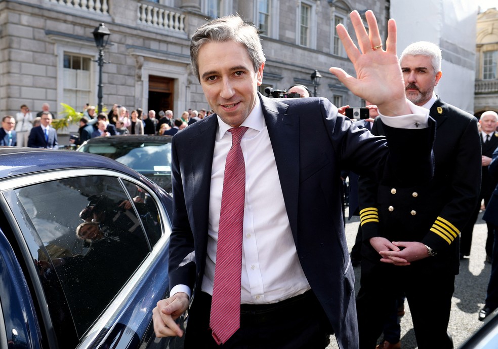 Simon Harris acena para apoiadores ao sair da sede do Parlamento irlandês — Foto: MAXWELLS / HOUSES OF THE OIREACHTAS / AFP