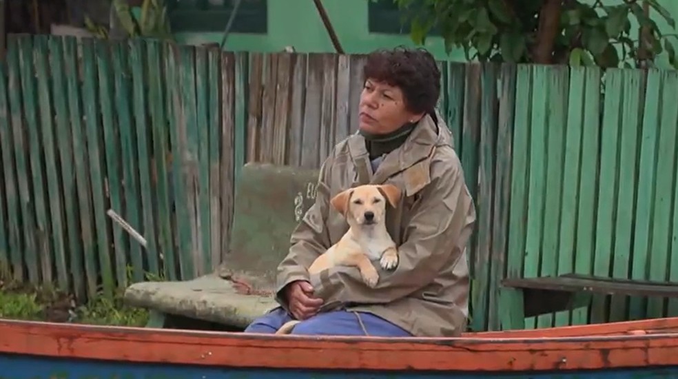 Moradores saem de casa com seus animais, fugindo da enchente em Pelotas. — Foto: TV Globo/Reprodução