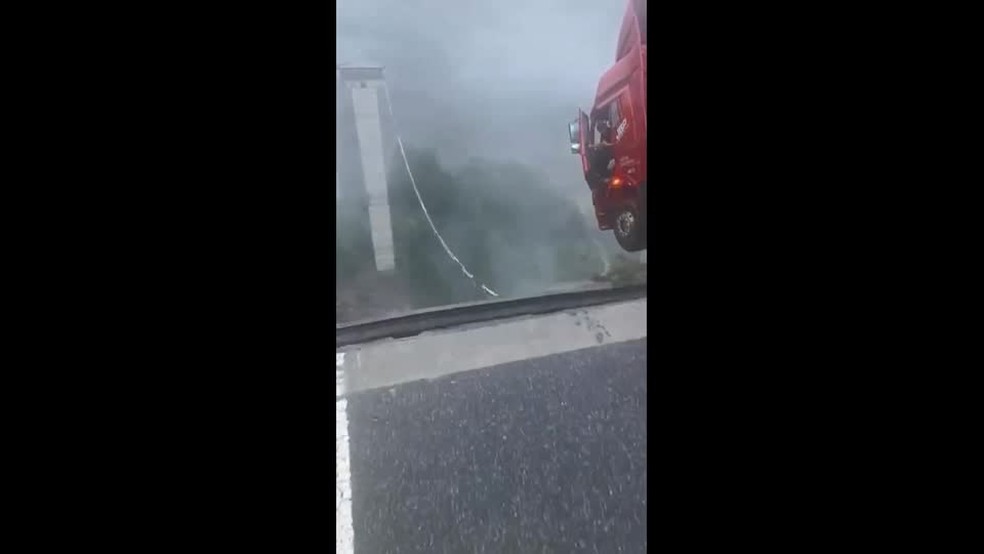 Motorista de caminhão preso à cabine após veículo ficar pendurado à beira de rodovia que desabou na China — Foto: REUTERS