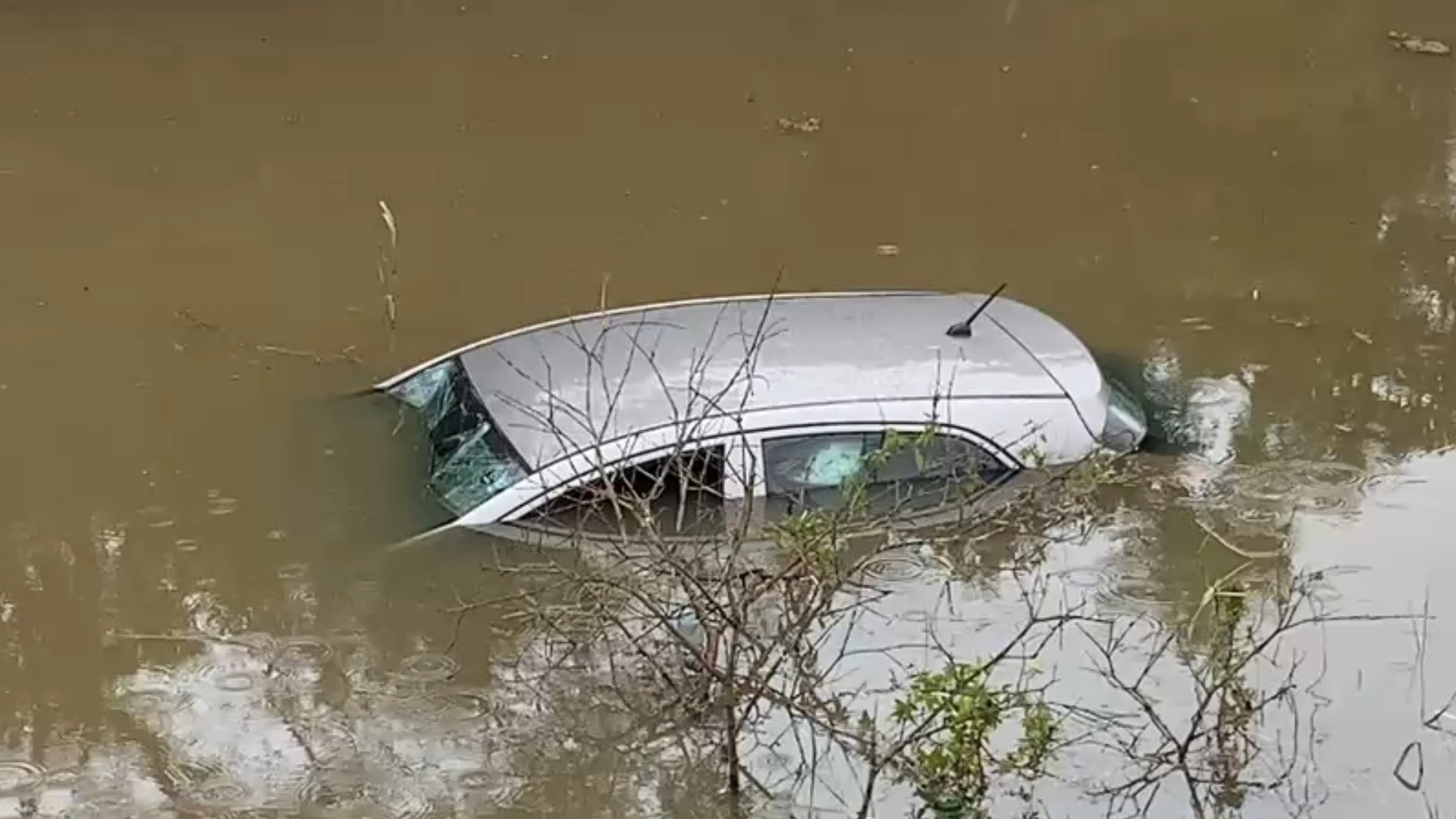 Motorista perde o controle de carro em pista molhada e veículo cai em córrego em Mogi das Cruzes