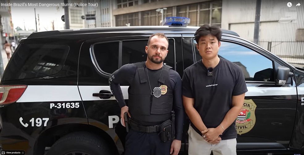 Youtuber posa ao lado de policial civil durante documentário em que passou 24 horas com a polícia — Foto: Reprodução/YouTube