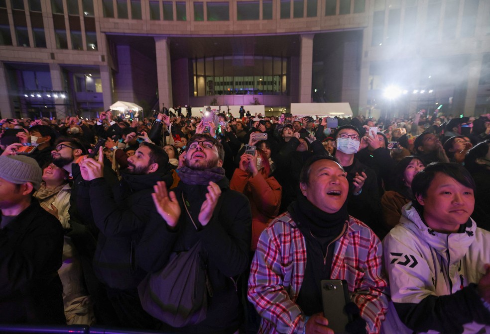 Pessoas reagem após a contagem regressiva para o Ano Novo em frente ao prédio do Governo Metropolitano de Tóquio — Foto: REUTERS/Issei Kato