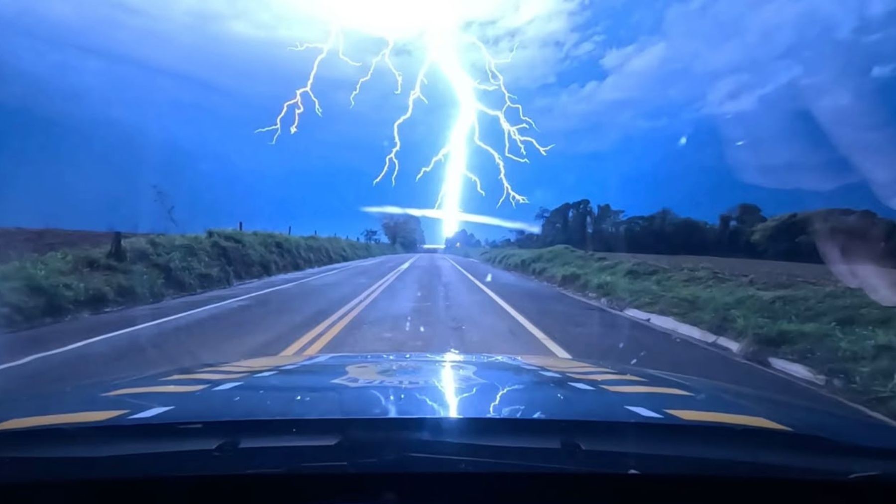 VÍDEO: câmera de viatura registra momento em que raio atinge margem de rodovia durante temporal no Paraná