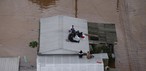 Moradores aguardam resgate no telhado de casa em Canos, no Rio Grande do Sul, no dia 4 de maio de 2024 — Foto: REUTERS/Renan Mattos