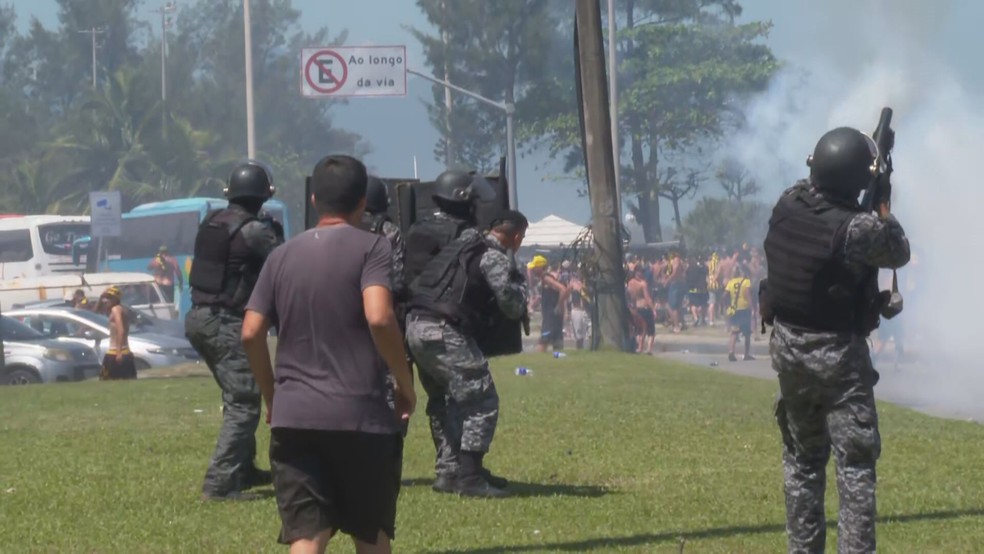 Policiais enfrentam torcedores do Peñarol na orla do Recreio dos Bandeirantes — Foto: Reprodução/ TV Globo