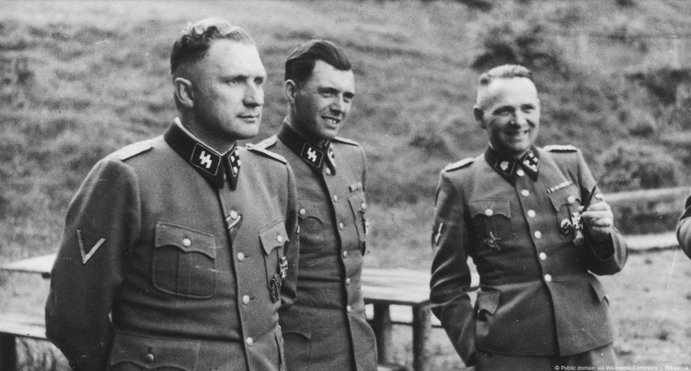 Mengele (no centro) em Auschwitz em 1944, ao lado de Richard Baer e Rudolf Höss — Foto: Public domain via Wikimedia Commons / Wikipedia