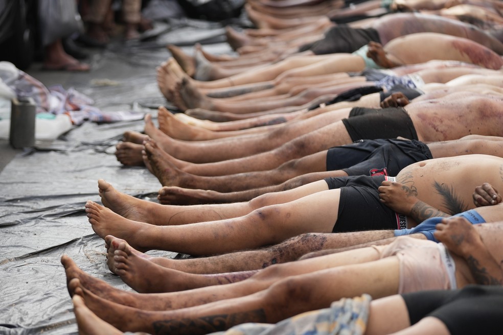 Foto mostra corpos colocados em praça no Complexo da Penha, no dia seguinte à operação mais letal da história do RJ — Foto: AP Photo/Silvia Izquierdo