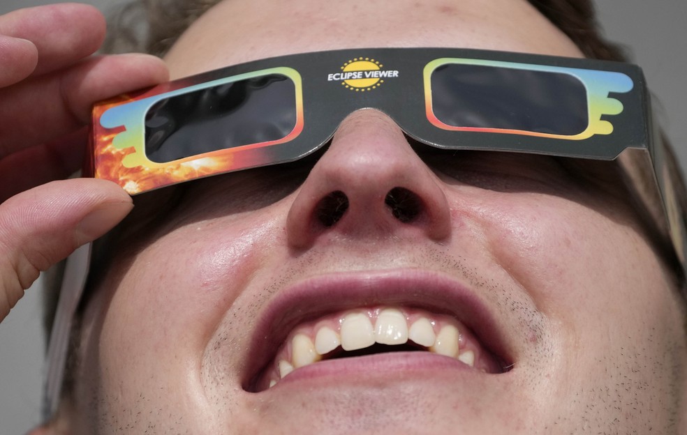 Homem usa &oacute;culos especiais para assistir eclipse  &mdash; Foto: Frank Augstein/AP