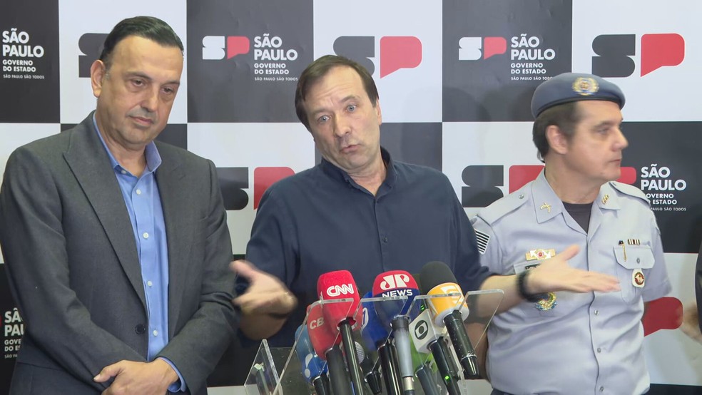 O secretário estadual de Desenvolvimento Urbano e Habitação, Marcelo Cardinale Branco, ao lado do vice-governador Felício Ramuth (PSD) e representante da Polícia Militar. — Foto: Reprodução/TV Globo