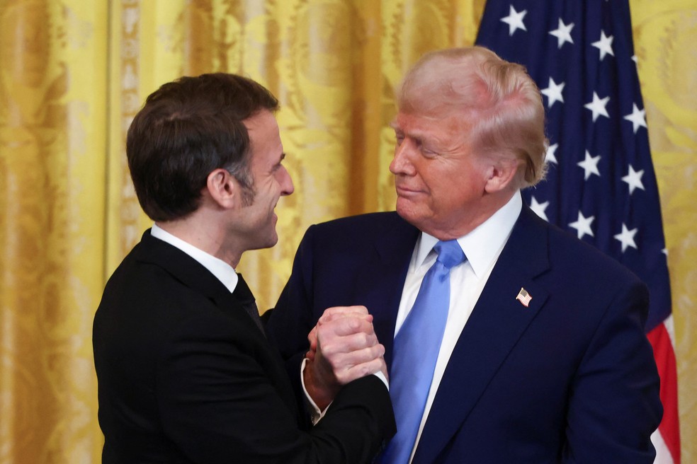 Emmanuel Macron e Donald Trump se cumprimentam após encontro na Casa Branca — Foto: Evelyn Hockstein/Reuters