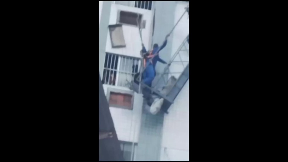 Trabalhadores ficaram pendurados em andaime que despencou do alto de prédio no Recife — Foto: Reprodução/WhatsApp