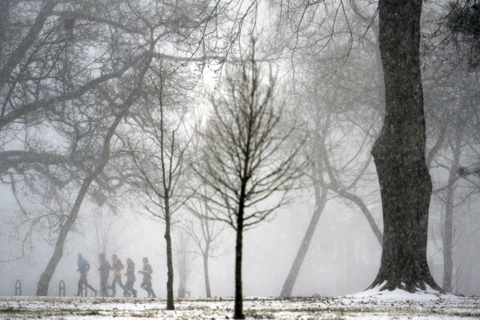 Pessoas tentam correr na tempestade de neve em St. Louis, Missouri, no domingo (5). — Foto: Jeff Roberson/AP
