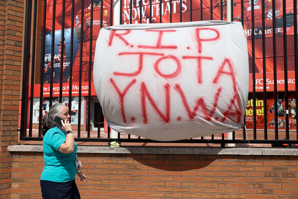 Faixa "Descanse em paz, Jota. YNWA", em referência a um famoso lema da torcida, acrônimo para "Você nunca andará sozinho", em português, instalado em grade em frente ao Anfield em 3 de julho de 2025. — Foto: REUTERS/Temilade Adelaja