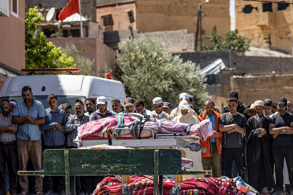 Moradores do vilarejo de Moulay Brahim, um dos mais afetados pelo terremoto, rezam diante de vítimas da tragédia. — Foto: Fadel Senna/AFP