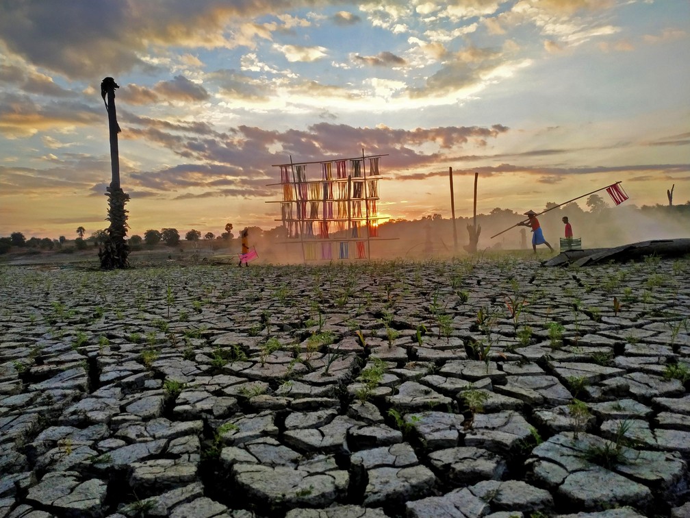 Nesta foto, Zaw Zaw Wai, de Mianmar, registrou família tingindo tecidos de algodão sobre o solo extremamente seco da região. Secas são comuns na Zona Seca de Mianmar, onde grande parte do algodão do país é cultivado. — Foto: Zaw Zaw Wai