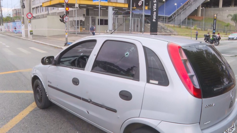 Carro cheio de marcas de tiro interdita a Avenida Eliseu de Almeida, na Vila Sônia, na manhã desta segunda-feira (17). — Foto: Reprodução/TV Globo