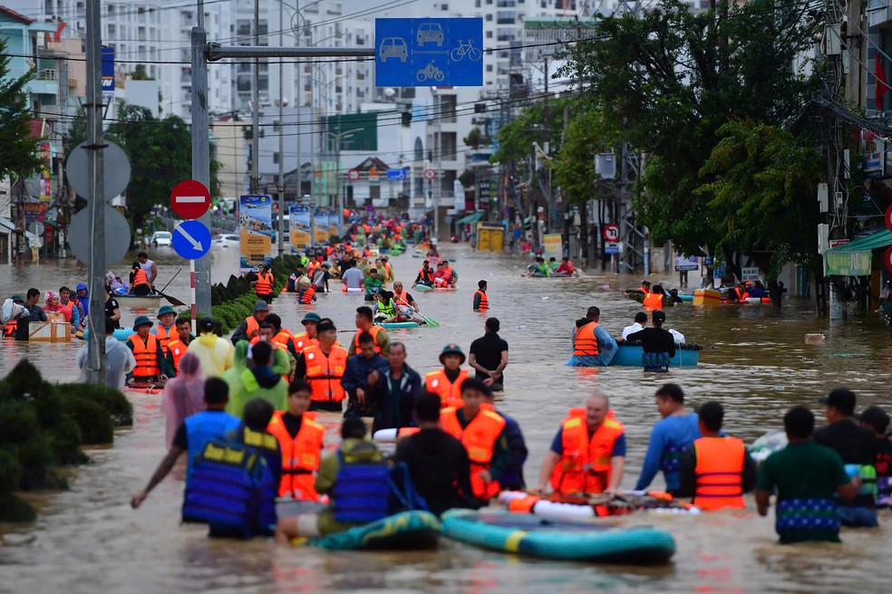 População enfrenta enchente em Nha Thang, no Vietnã, em imagem de 20 de novembro — Foto: DUC THAO / AFP
