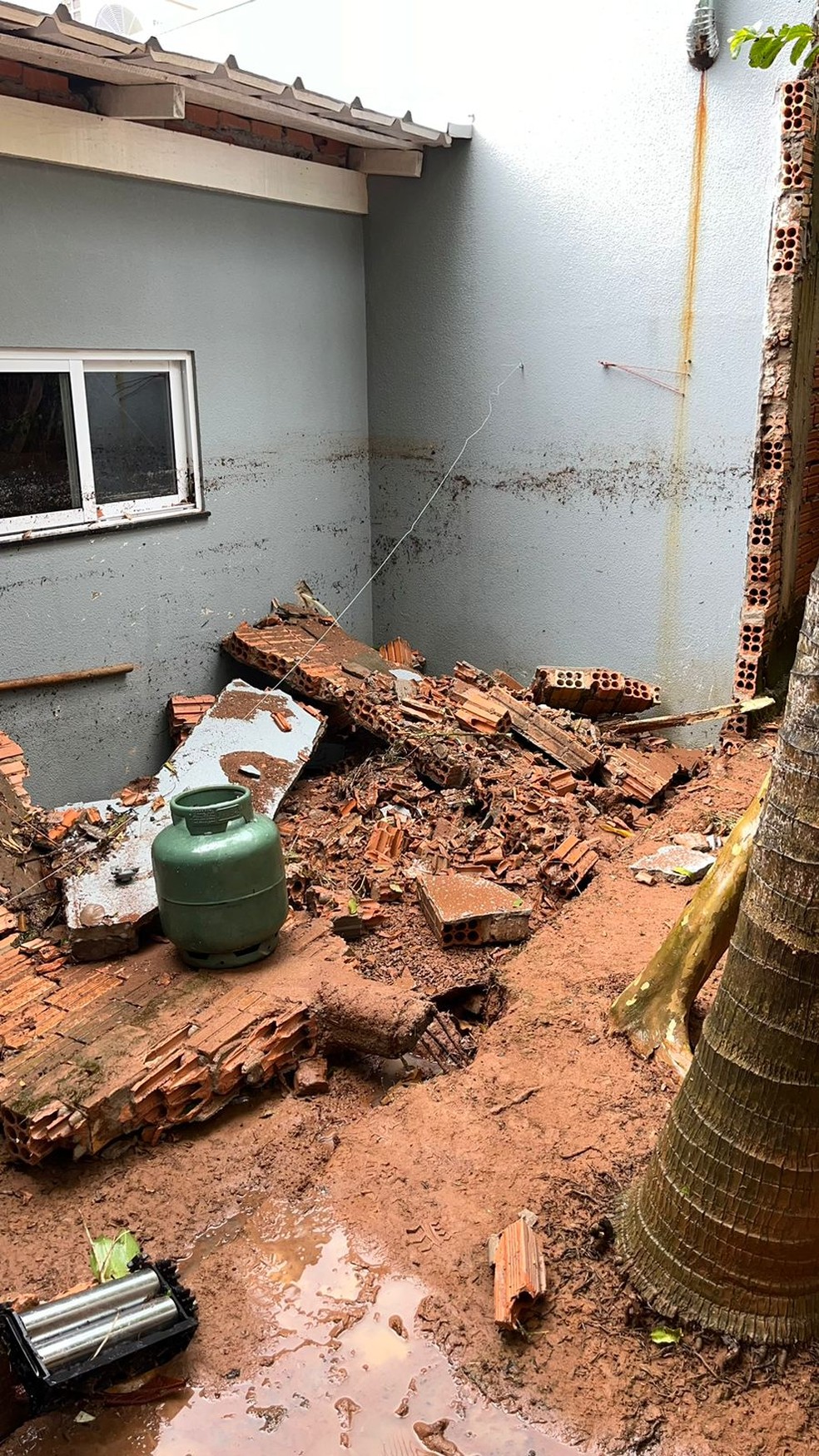 A pressão resultante derrubou os muros de duas residências vizinhas  — Foto: 10ª CIBM de Sorriso