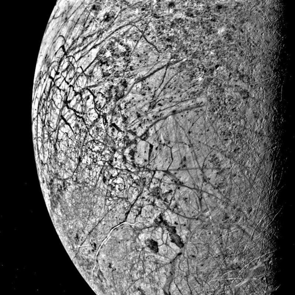 Duas espaçonaves devem visitar Europa, uma das luas de Júpiter, para estudar a extensão do oceano existente abaixo da sua superfície fraturada — Foto: Nasa/BBC