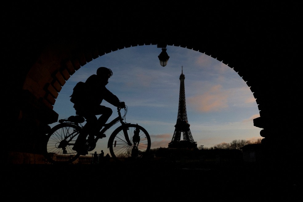 Imagem de ciclista perto da Torre Eiffel, em Paris  Foto: Gonzalo Fuentes/Reuters