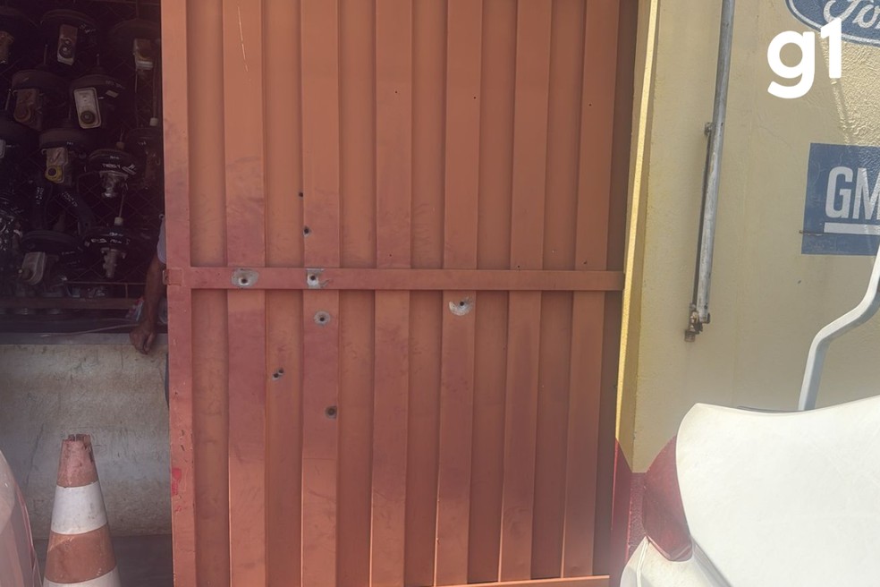 Portão da empresa com marcas de tiros após ataque — Foto: Reprodução