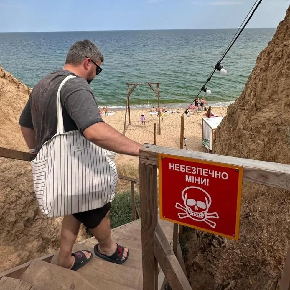 Na praia, há avisos sobre a presença de minas explosivas — Foto: BBC