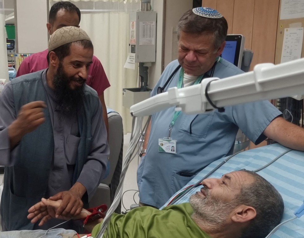 O árabe-isralense Qaid Farhan Al-Qadi, que havia sido sequestrado pelo Hamas, é observado por seu irmão e um médico israelense em hospital após ser resgatado na Faixa de Gaza, em 27 de agosto de 2024. — Foto: Centro Médico Soroka via Reuters