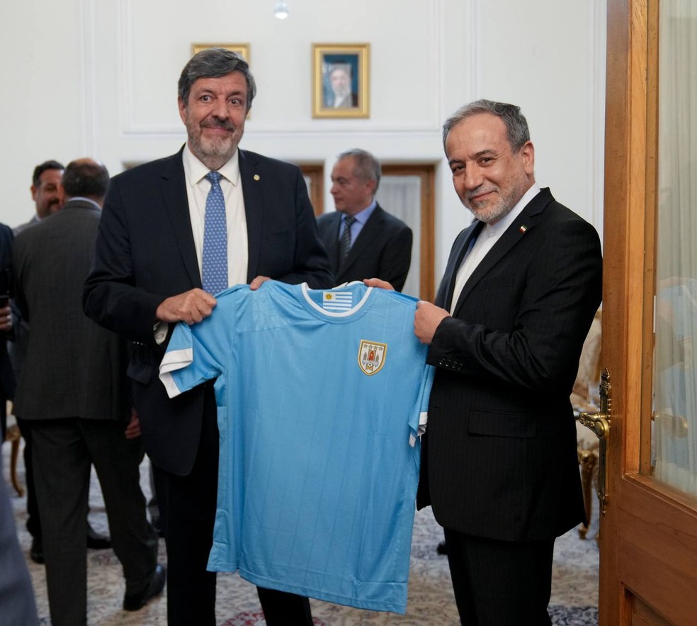Abbas Araqchi sendo presenteado por embaixador com a camisa da Seleção do Uruguai — Foto: Telegram / Divulgação
