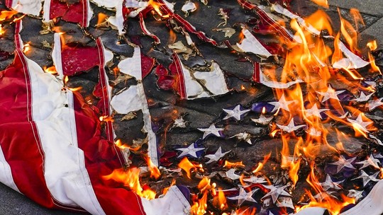 Homem é preso por queimar bandeira dos EUA ao protestar contra ordem de Trump - Presidente assinou medida que autoriza agentes punirem quem queimar a bandeira americana. Suprema Corte diz que ato é protegido pela Constituição.