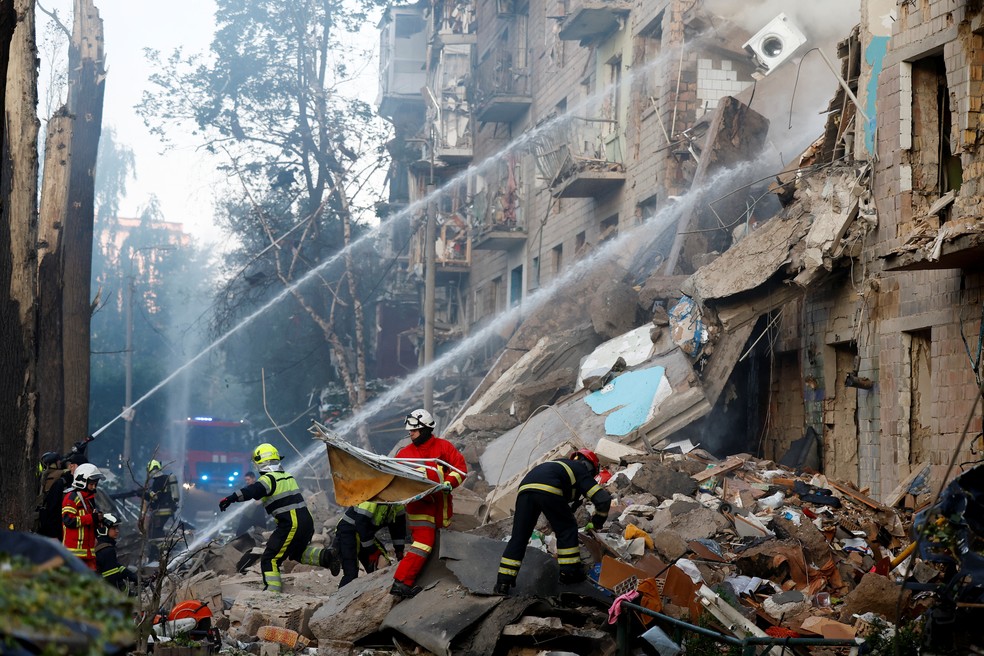 Equipes de resgate trabalham em locais atingidos por drones e mísseis russos — Foto: REUTERS/Thomas Peter